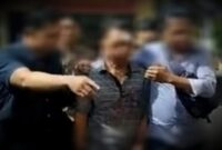 Pelaku (tengah) digelandang polisi usai babak belur (Foto Istimewa)