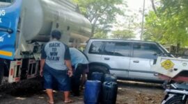 Anak buah Aipda JR tampak sibuk memindahkan isi muatan BBM dari tangki ke dalam jerigen 