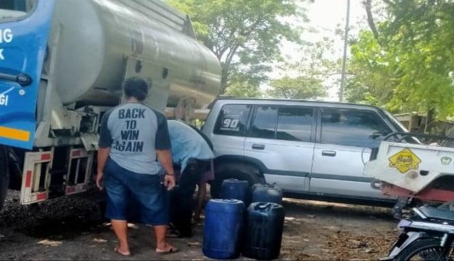 Anak buah Aipda JR tampak sibuk memindahkan isi muatan BBM dari tangki ke dalam jerigen 