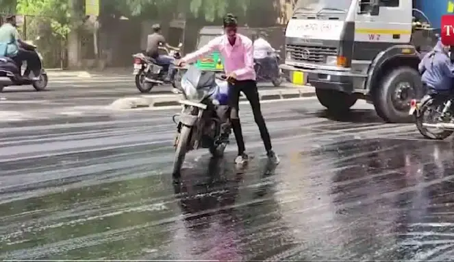 Seorang pengendara motor yang terjebak aspal mencair (Times of India)