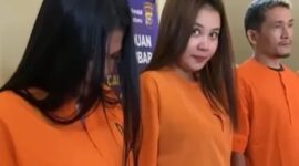 Seorang wanita pemakai sabu tersenyum lebar ke kamera dengan mengenakan baju tahanan usai ditangkap polisi. (Ist)