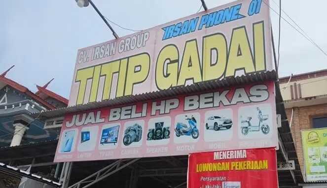 Papan nama CV Irsan Group - Irsan Phone 01 yang bergerak di bidang titip gadai dan jual beli HP bekas di Kabupaten Gowa.