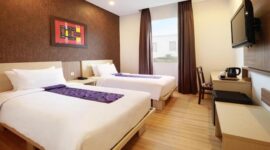 Kamar tamu Swiss-Belinn Panakkukang dengan dua tempat tidur single, desain modern, dan fasilitas lengkap.