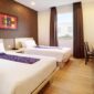 Kamar tamu Swiss-Belinn Panakkukang dengan dua tempat tidur single, desain modern, dan fasilitas lengkap.