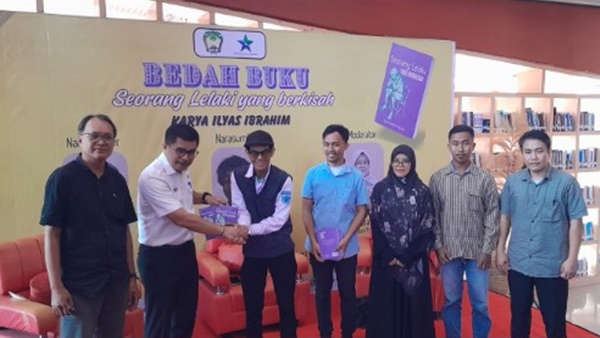 Para peserta dan narasumber berfoto bersama dalam kegiatan Bedah Buku 