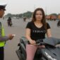 Foto ilustrasi – Oknum Polantas tilang seorang pengendara motor wanita di tengah jalan raya.