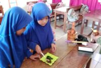 Dua siswi SD Negeri Parinring Makassar sedang mempraktikkan pembuatan masker herbal dari daun katuk di dalam kelas.