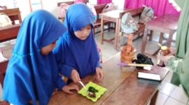 Dua siswi SD Negeri Parinring Makassar sedang mempraktikkan pembuatan masker herbal dari daun katuk di dalam kelas. 