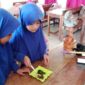 Dua siswi SD Negeri Parinring Makassar sedang mempraktikkan pembuatan masker herbal dari daun katuk di dalam kelas. 
