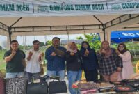 PT Pegadaian Syariah Keutapang bersama panitia Bazar UMKM berfoto di salah satu stan produk lokal di Gampong UMKM Cot Iri