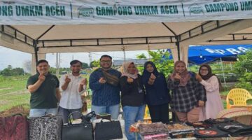 PT Pegadaian Syariah Keutapang bersama panitia Bazar UMKM berfoto di salah satu stan produk lokal di Gampong UMKM Cot Iri