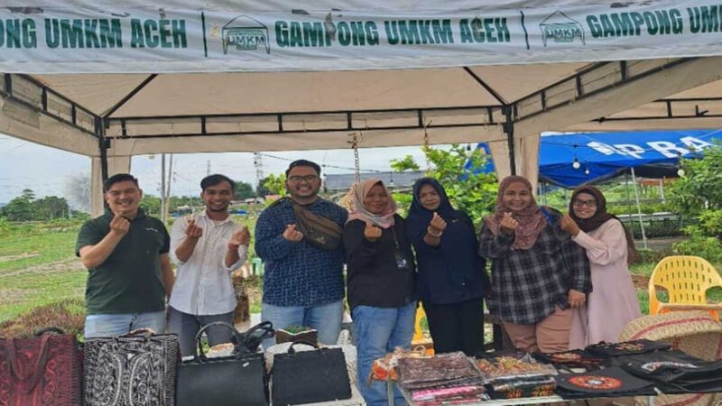 PT Pegadaian Syariah Keutapang bersama panitia Bazar UMKM berfoto di salah satu stan produk lokal di Gampong UMKM Cot Iri