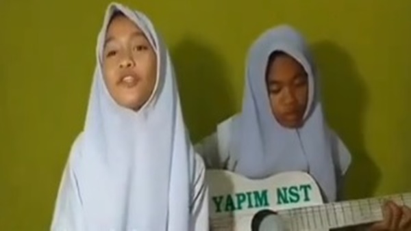 Tangkapan layar video – Dua bocah pengamen perempuan yang mengkritik Jokowi lewat lagu