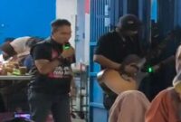 Udhin Leaders (kiri) saat ikut bernyanyi dengan seorang pengamen (kanan) yang menyanyikan lagu Salimu Naraka