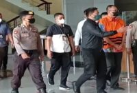 Rafael memakai baju orange dengan tangan di borgol
