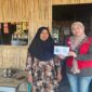 Mahasiswa KKN Unhas 114, Nur Asma-ul Husna Zahrah Firdaus, menyerahkan buku saku panduan desain promosi dan pendaftaran Google Maps kepada salah satu pelaku UMKM di Desa Teteaji.