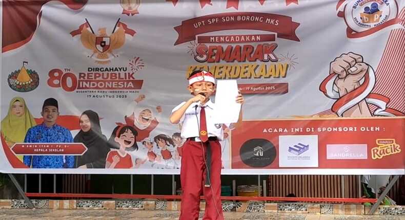 Siswa SD Negeri Borong Makassar membaca puisi dengan menggunakan ikat kepala totopong merah putih