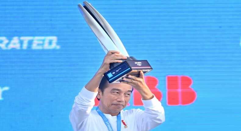 Mantan Presiden RI ke-7, Jokowi saat menyerahkan piala ke pembalap Jaguar TCS Mitch Evans di podium. (Foto ANTARA/Hafidz Mubarak A).