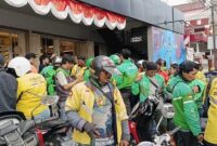 Sejumlah pengemudi ojek online (ojol) antusias mengantre menerima parfum gratis saat perayaan Anniversary ke-17 Raja Wangi di Jalan Sunu, Makassar.