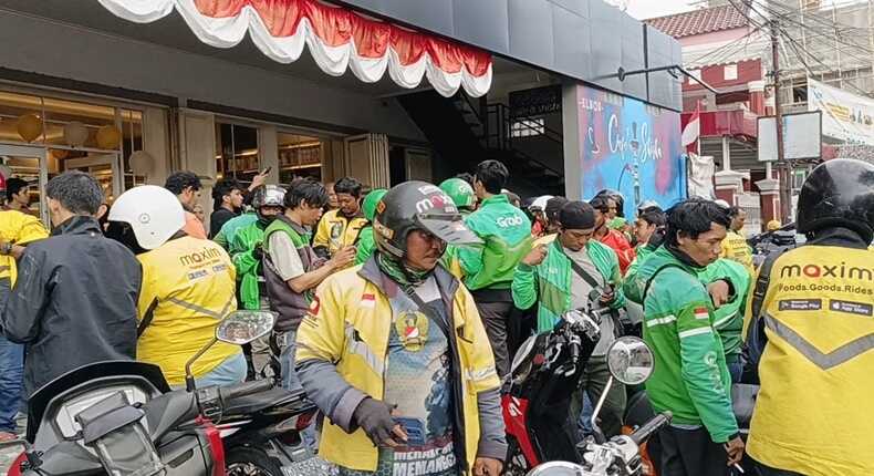 Sejumlah pengemudi ojek online (ojol) antusias mengantre menerima parfum gratis saat perayaan Anniversary ke-17 Raja Wangi di Jalan Sunu, Makassar.