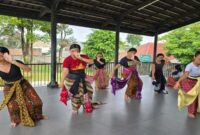 Penari muda sedang berlatih Tari Bedhaya Gandrungmanis di sebuah pendopo terbuka. Mereka mengenakan kain tradisional Jawa dan menampilkan gerakan khas Bedhaya, bagian dari persiapan pementasan Langen Mataya Bedhayan Gandrungmanis.