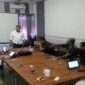 Dewan Pendiri Serikat Insan Media (SIM), Ibhe Ananda (berdiri mengenakan kemeja putih), memimpin rapat bersama anggota SIM di sebuah ruang pertemuan.