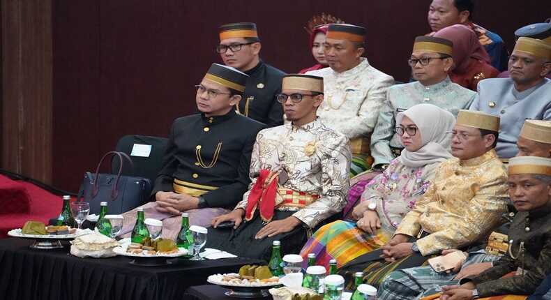 Putra Mahkota Kerajaan Gowa duduk di tengah mengenakan pakaian adat lengkap dengan keris.