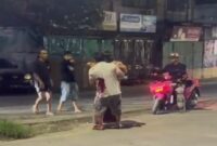 Tangkapan layar video menunjukkan oknum TNI AU ngamuk dan menikam pria yang diduga selingkuhan istrinya di Sudiang, sementara warga sekitar menyaksikan insiden tersebut.