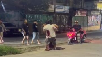 Tangkapan layar video menunjukkan oknum TNI AU ngamuk dan menikam pria yang diduga selingkuhan istrinya di Sudiang, sementara warga sekitar menyaksikan insiden tersebut.