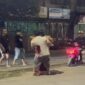 Tangkapan layar video menunjukkan oknum TNI AU ngamuk dan menikam pria yang diduga selingkuhan istrinya di Sudiang, sementara warga sekitar menyaksikan insiden tersebut.