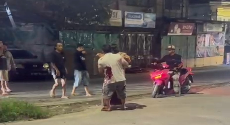 Tangkapan layar video menunjukkan oknum TNI AU ngamuk dan menikam pria yang diduga selingkuhan istrinya di Sudiang, sementara warga sekitar menyaksikan insiden tersebut.