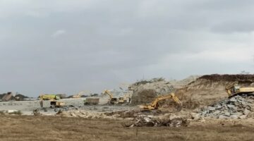 Alat berat tampak beroperasi di lokasi tambang galian C ilegal di kawasan gudang 88 Kota Makassar.