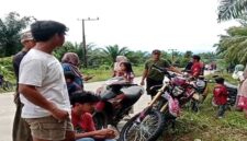 Warga Desa Rampoang berkumpul di tepi jalan sambil memantau aktivitas di sekitar lokasi proyek pembangunan Yon TP 872/Andi Jemma yang sementara dihentikan, Minggu (23/11/2025).