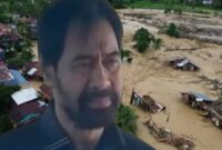 Gubernur Aceh, Mualem, dengan latar belakang pemandangan yang terdampak banjir