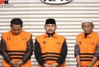 Ade Kuswara (tengah) dan HM Kunang (kanan) mengenakan rompi tahanan oranye khas KPK saat dihadirkan dalam konferensi pers di Gedung KPK, Jakarta. (Ist)