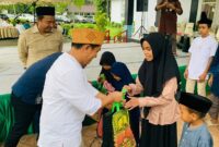 Ketua DPRD Luwu Utara, Husain, saat menyerahkan santunan kepada anak yatim dalam kegiatan silaturahmi dan buka puasa bersama di Kantor DPRD Luwu Utara.