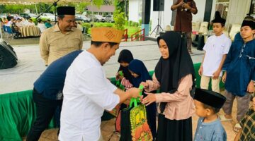 Ketua DPRD Luwu Utara, Husain, saat menyerahkan santunan kepada anak yatim dalam kegiatan silaturahmi dan buka puasa bersama di Kantor DPRD Luwu Utara.