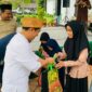 Ketua DPRD Luwu Utara, Husain, saat menyerahkan santunan kepada anak yatim dalam kegiatan silaturahmi dan buka puasa bersama di Kantor DPRD Luwu Utara.