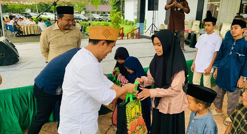 Ketua DPRD Luwu Utara, Husain, saat menyerahkan santunan kepada anak yatim dalam kegiatan silaturahmi dan buka puasa bersama di Kantor DPRD Luwu Utara.