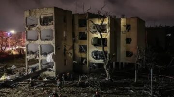 Petugas keamanan dan tim penyelamat berada di lokasi dampak serangan rudal Iran di Arad, Israel selatan, Minggu (22/3/2026). (AFP/Ilia Yefimovich)