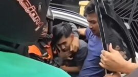Tangkapan layar video memperlihatkan seorang pemuda di Makassar diseret keluar dari mobil dan menjadi sasaran amukan massa.