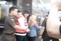 Mantan Pj Gubernur Sulsel, Bahtiar Baharuddin, digiring penyidik Kejati Sulsel mengenakan rompi tahanan merah dan topi usai ditetapkan sebagai tersangka kasus dugaan korupsi pengadaan bibit nanas.