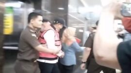 Mantan Pj Gubernur Sulsel, Bahtiar Baharuddin, digiring penyidik Kejati Sulsel mengenakan rompi tahanan merah dan topi usai ditetapkan sebagai tersangka kasus dugaan korupsi pengadaan bibit nanas.