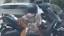 Tangkapan layar video viral yang memperlihatkan aksi seorang pengendara motor mengangkut motor lain di jalanan Kota Makassar. Polisi kini tengah menelusuri identitas pengendara dan wanita yang ada dalam video tersebut untuk diberikan sanksi tilang karena tindakannya membahayakan keselamatan.