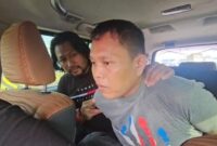 Pelaku penyekapan dan pemerkosaan di Makassar mengenakan baju abu-abu saat diamankan aparat kepolisian usai ditangkap di Surabaya, Jawa Timur.