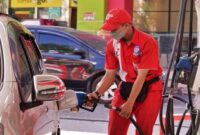 Petugas SPBU Pertamina saat melayani pengisian bahan bakar minyak (BBM) jenis Pertalite ke salah satu mobil konsumen