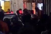 Tangkapan layar video menunjukkan massa mengepung rumah pelaku di Kecamatan Mariso, Makassar, Rabu (25/6/2026) malam, saat aparat kepolisian berupaya mengevakuasi terduga pelaku dari amukan warga di lokasi kejadian.