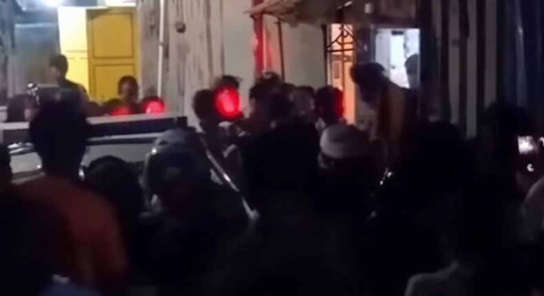 Tangkapan layar video menunjukkan massa mengepung rumah pelaku di Kecamatan Mariso, Makassar, Rabu (25/6/2026) malam, saat aparat kepolisian berupaya mengevakuasi terduga pelaku dari amukan warga di lokasi kejadian.
