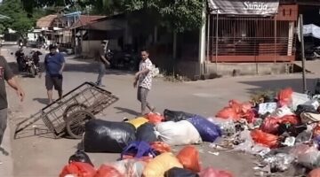 Tangkapan layar video saat warga menutup sebagian badan jalan dengan tumpukan sampah di sekitar Pasar Enrekang sebagai aksi protes atas keterlambatan pengangkutan sampah.