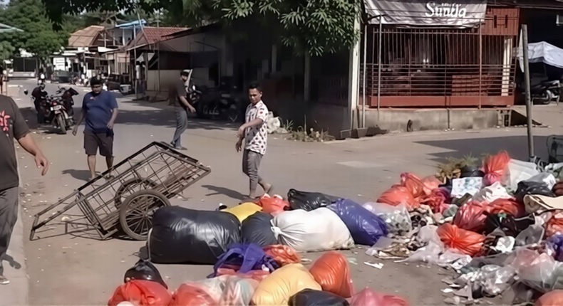 Tangkapan layar video saat warga menutup sebagian badan jalan dengan tumpukan sampah di sekitar Pasar Enrekang sebagai aksi protes atas keterlambatan pengangkutan sampah.